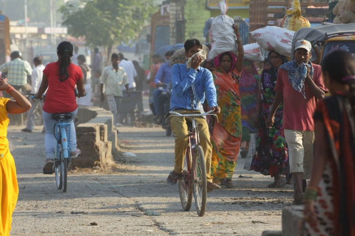 Boy on a cycle covering face with scarf